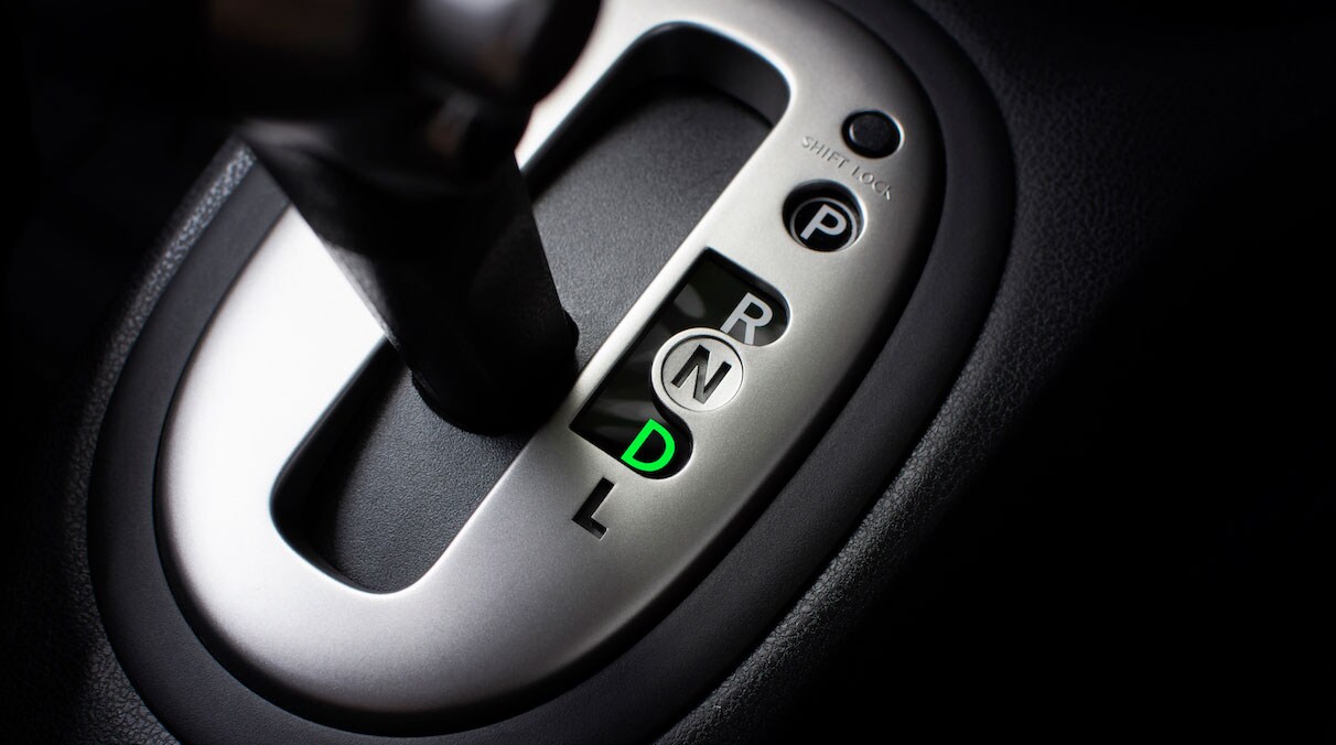 Ein Automatik-Wahl-Hebel aus einem Auto. Der Hebel ist auf D gestellt, die Ziffer leuchtet grün neben dem Hebel auf.